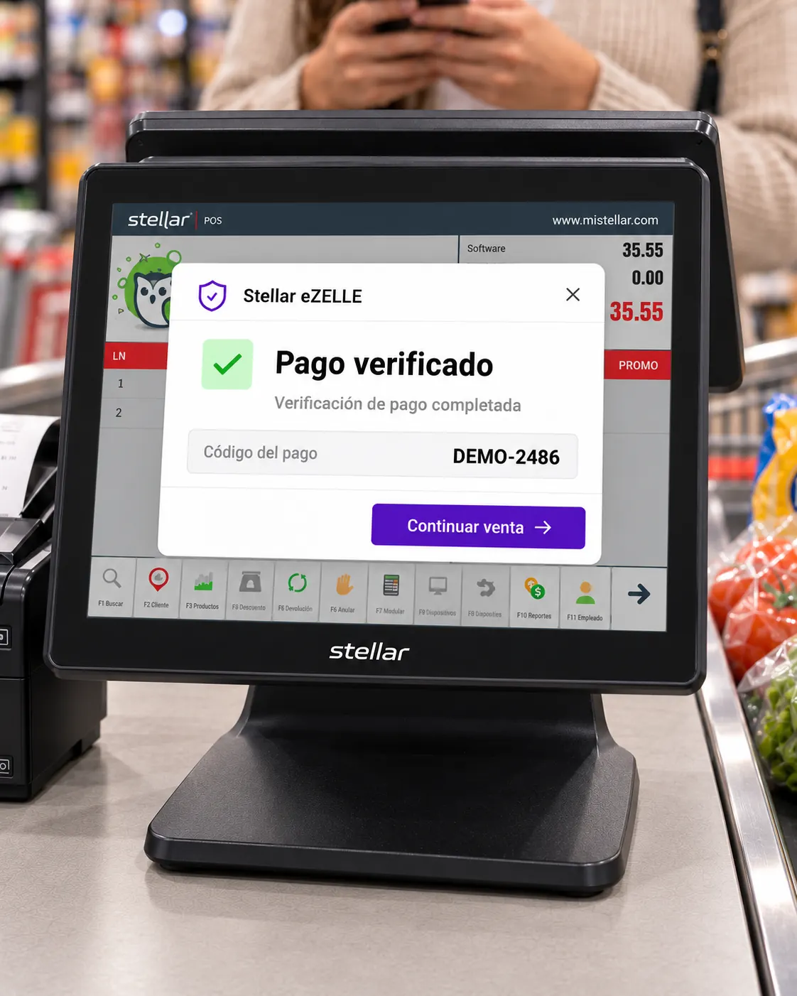 Primer plano del POS sobre el mueble fijo de una caja, separado de la cinta, con una interfaz representativa de eZELLE que muestra el código del pago, Pago verificado y Continuar venta